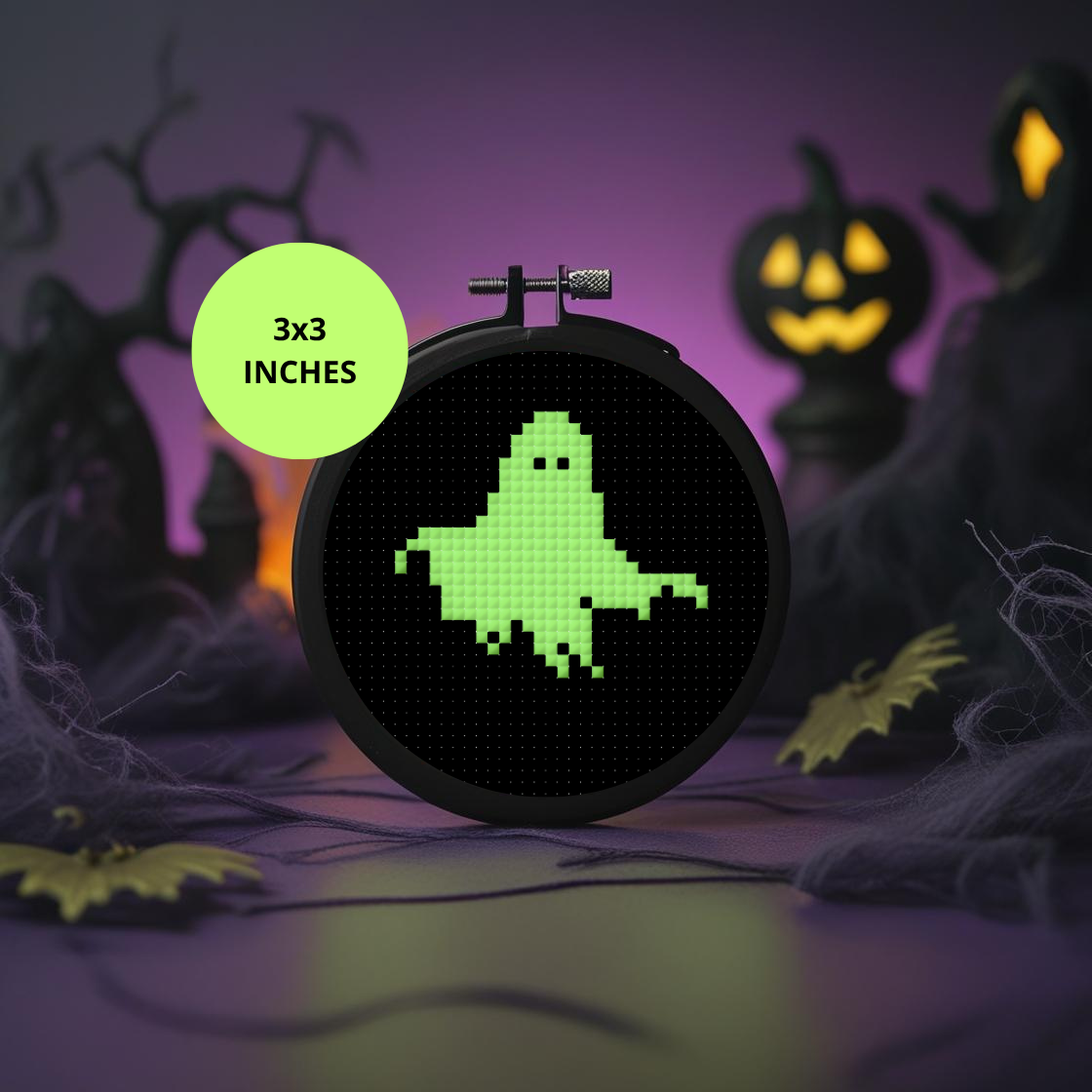 Cross-stitch hoop with a green ghost design on a Halloween-themed background
