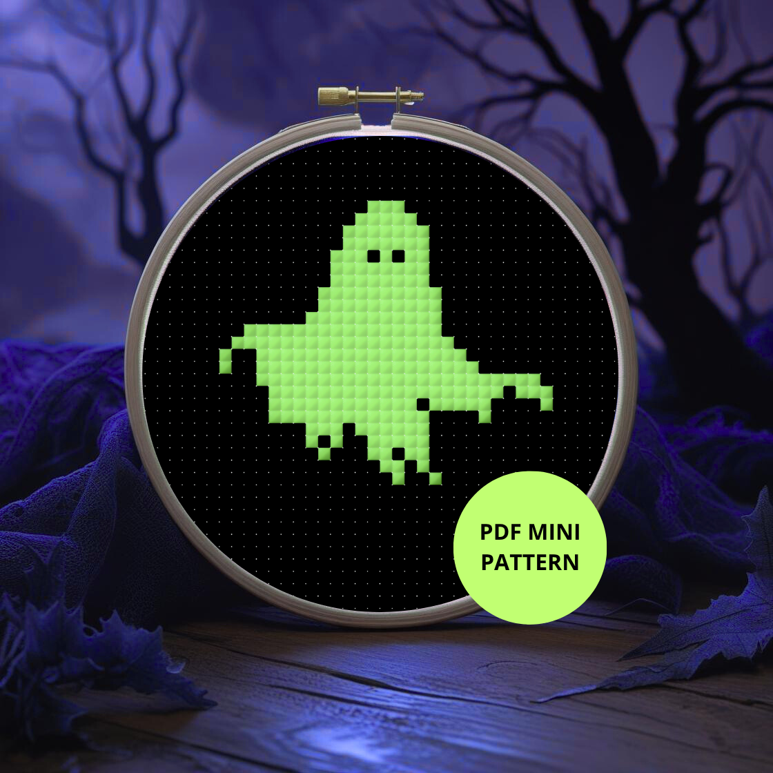 Embroidery hoop with pixelated ghost design against a dark background