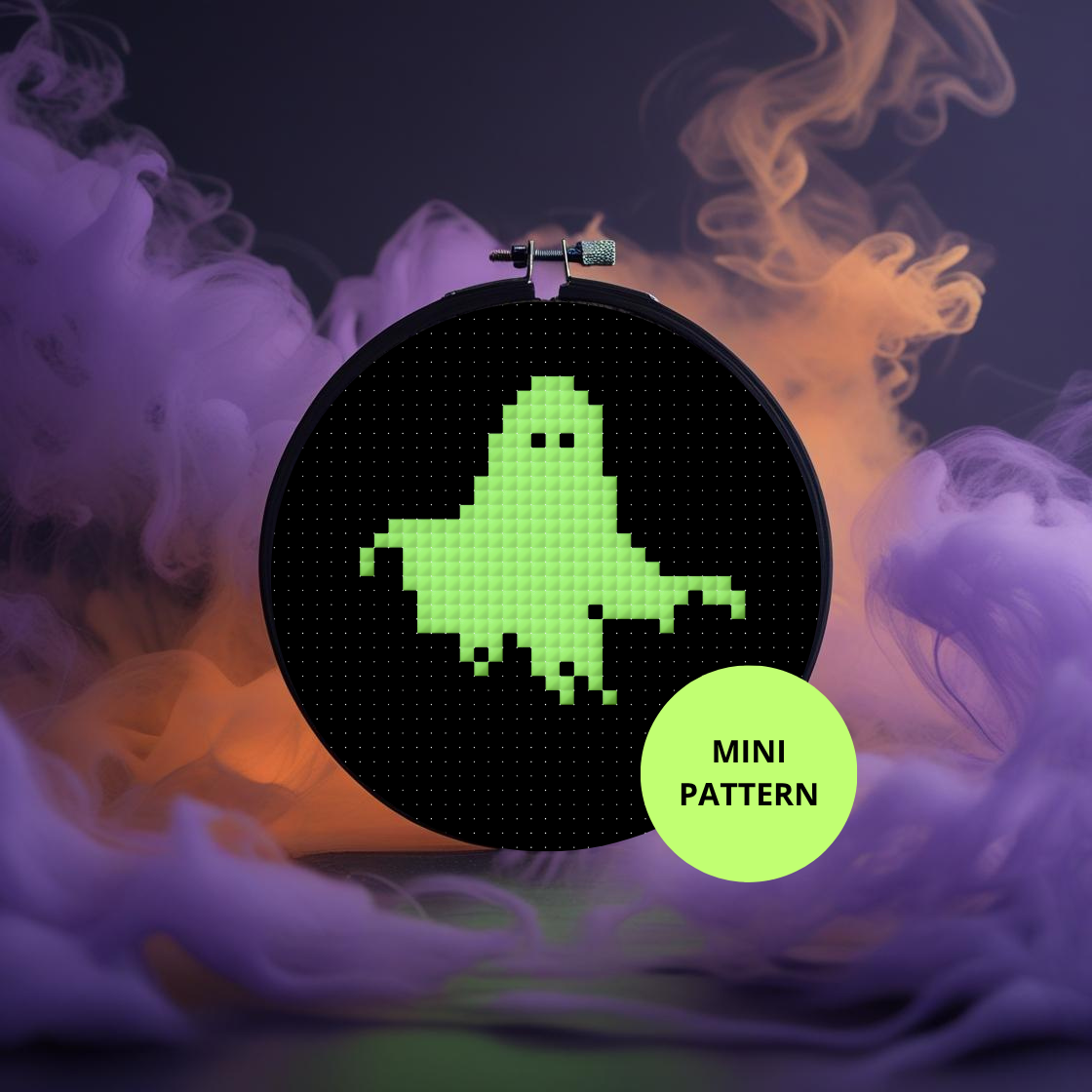 Cross-stitch hoop with a green ghost pattern on a dark background with colorful smoke effects